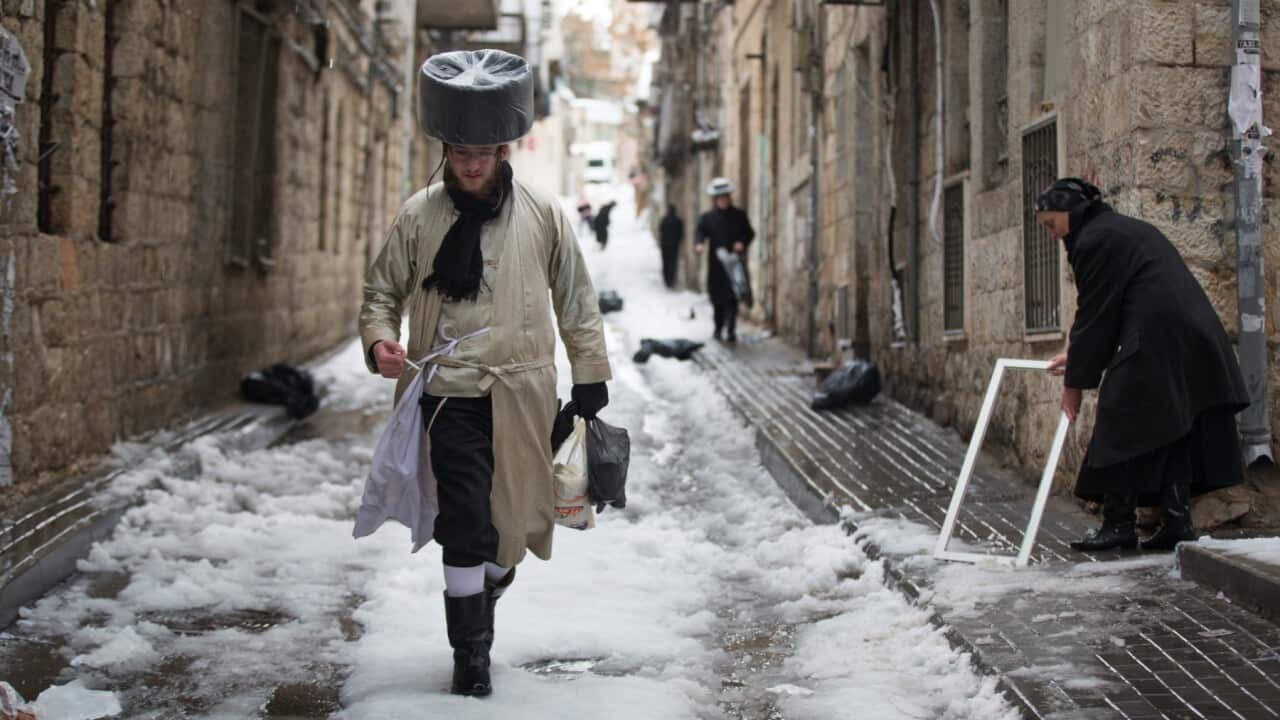 An Ultra orthodox jewish man walks in the snow ahead of Shabat (Saturday)