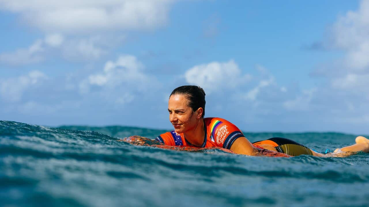 Tyler Wright on a surfboard paddling in water