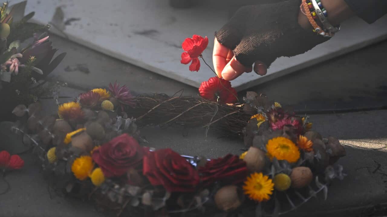 A person places a poppy at the ‘For Our Country’ memorial in Canberra