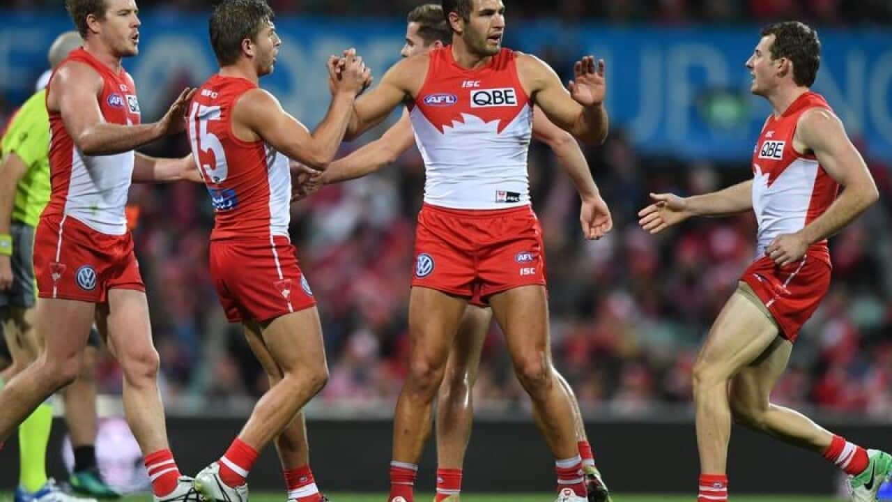 Josh Kennedy of the Swans (centre) celebrates after kicking a goal.