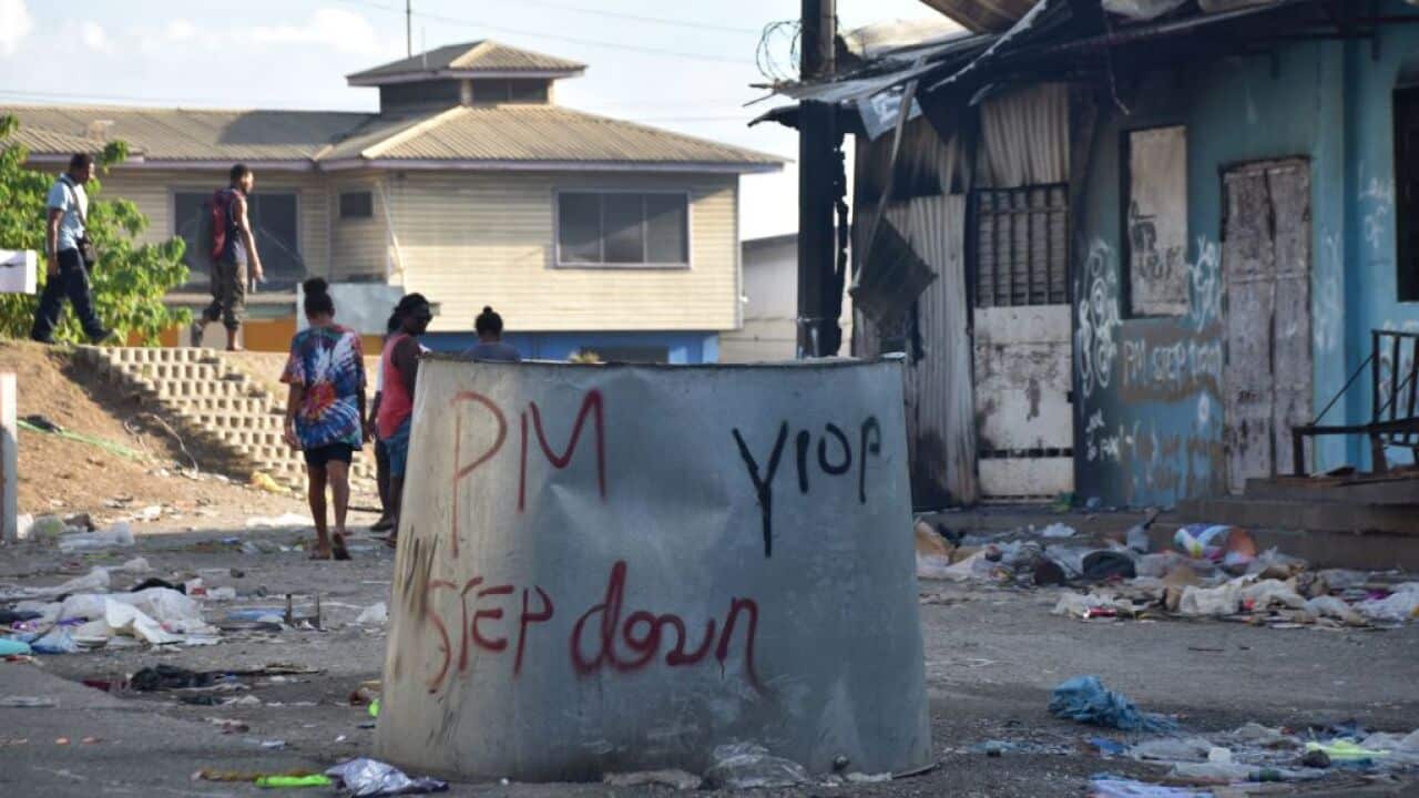 An anti-government message is seen by a burnt-out building in Honiara on November 27, 2021