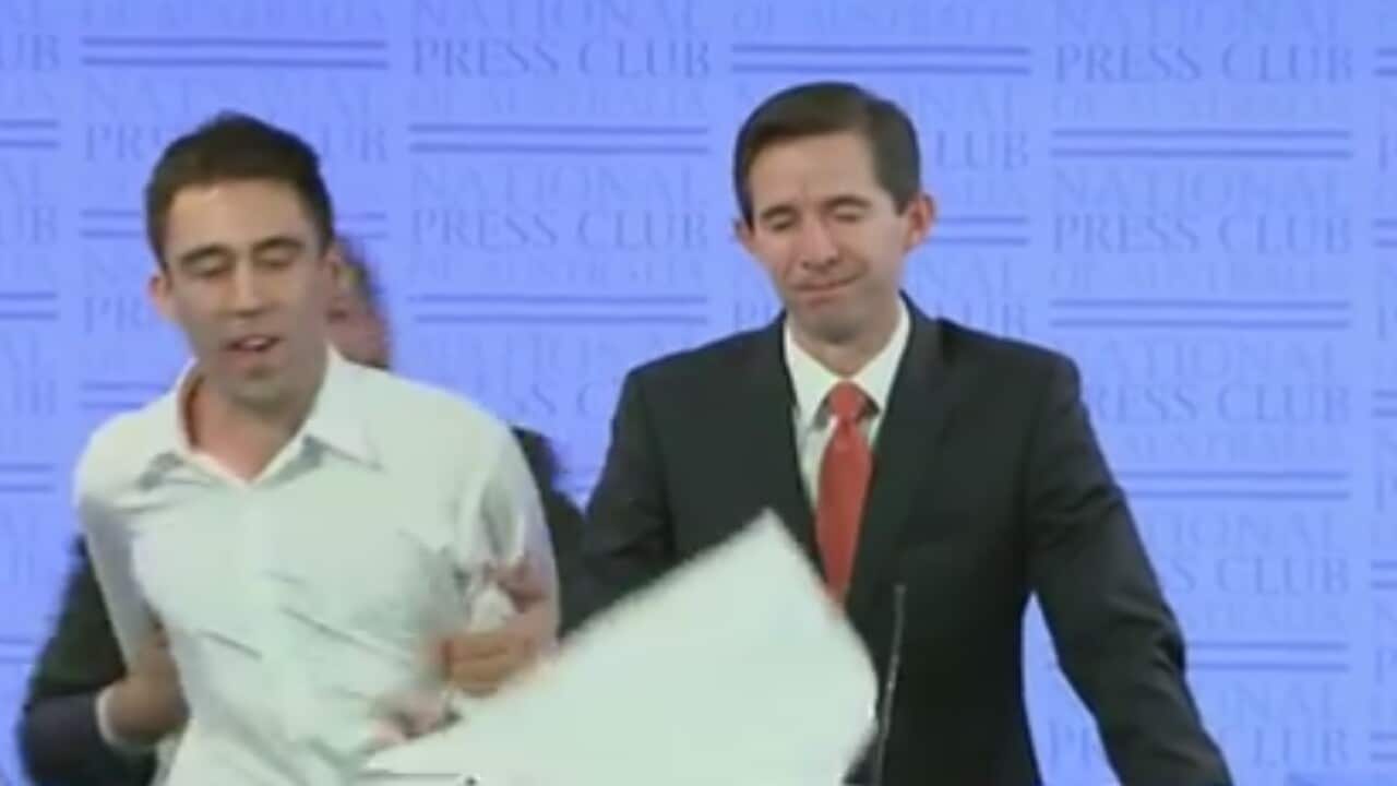 Education Minister Simon Birmingham (right) as protesters stormed the stage at the National Press Club in Canberra