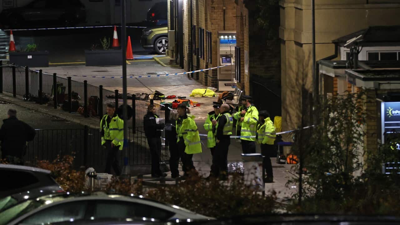 A group of police officers stand close to the emergency equipment left behind after an incident at Huntingdon train station in Cambridgeshire