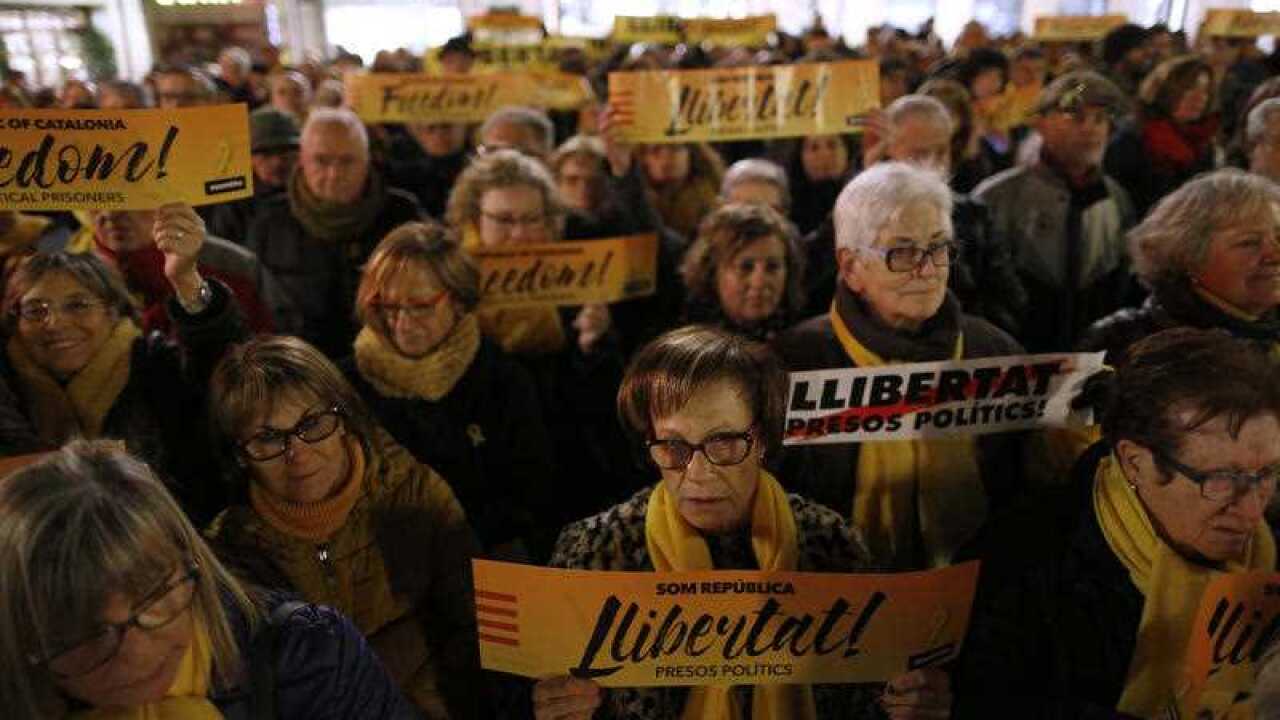 Demonstrators holding banners reading in Catalan "We are republic. Freedom for the political prisoners." during a protest in support of the politicians imprisoned in front of the city hall in Badalona, Spain, Monday, Jan. 15, 2018.