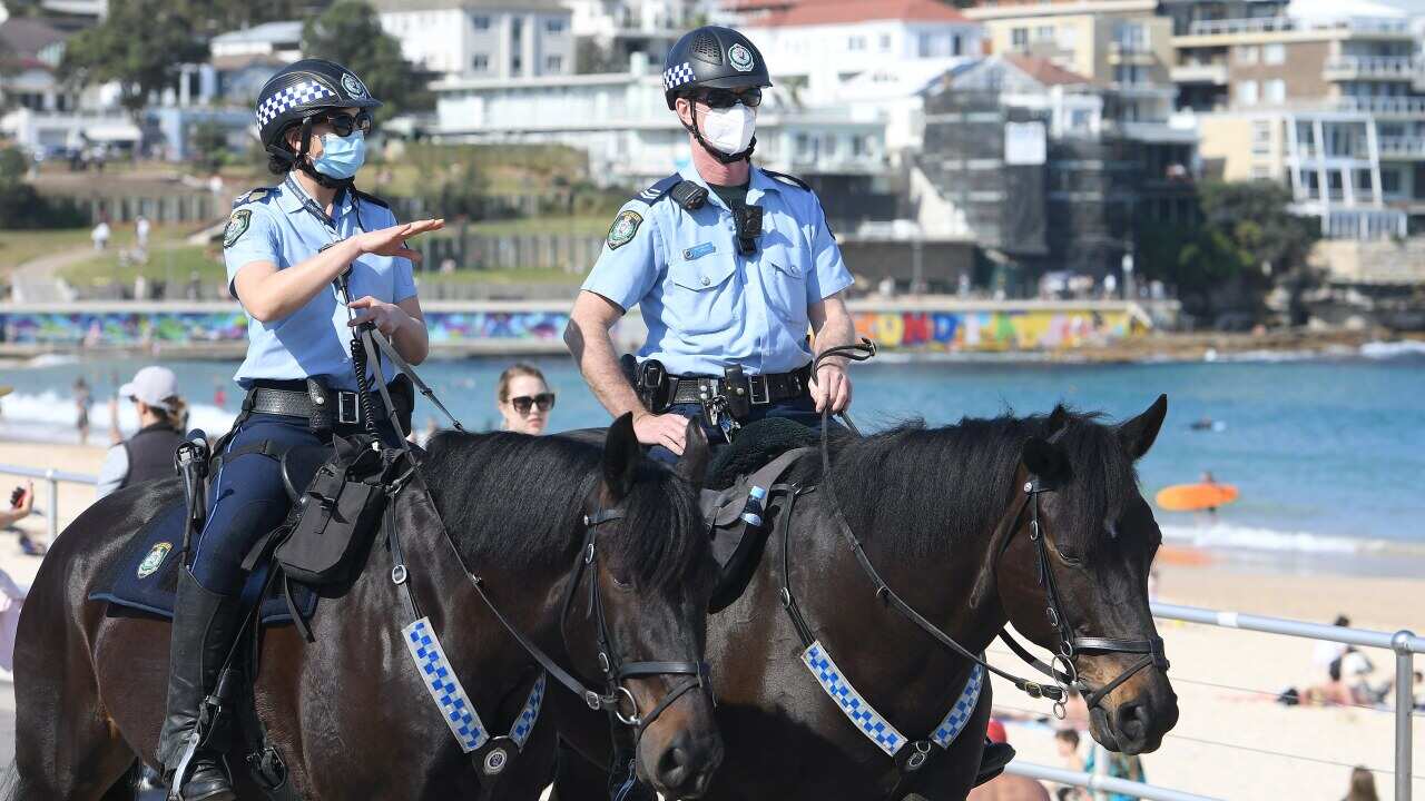 Police are seen patrolling Bondi Beach on horseback in Sydney, Saturday, 14 August.