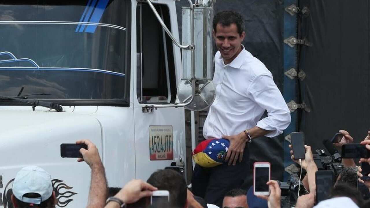 Juan Guaido greets supporters from an aid truck