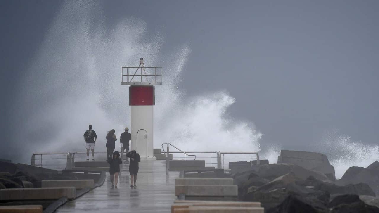 thumbnail_Waves crash onto rocks as people look on at the Spit, on the Seaway on the Gold Coast (AAP).jpg