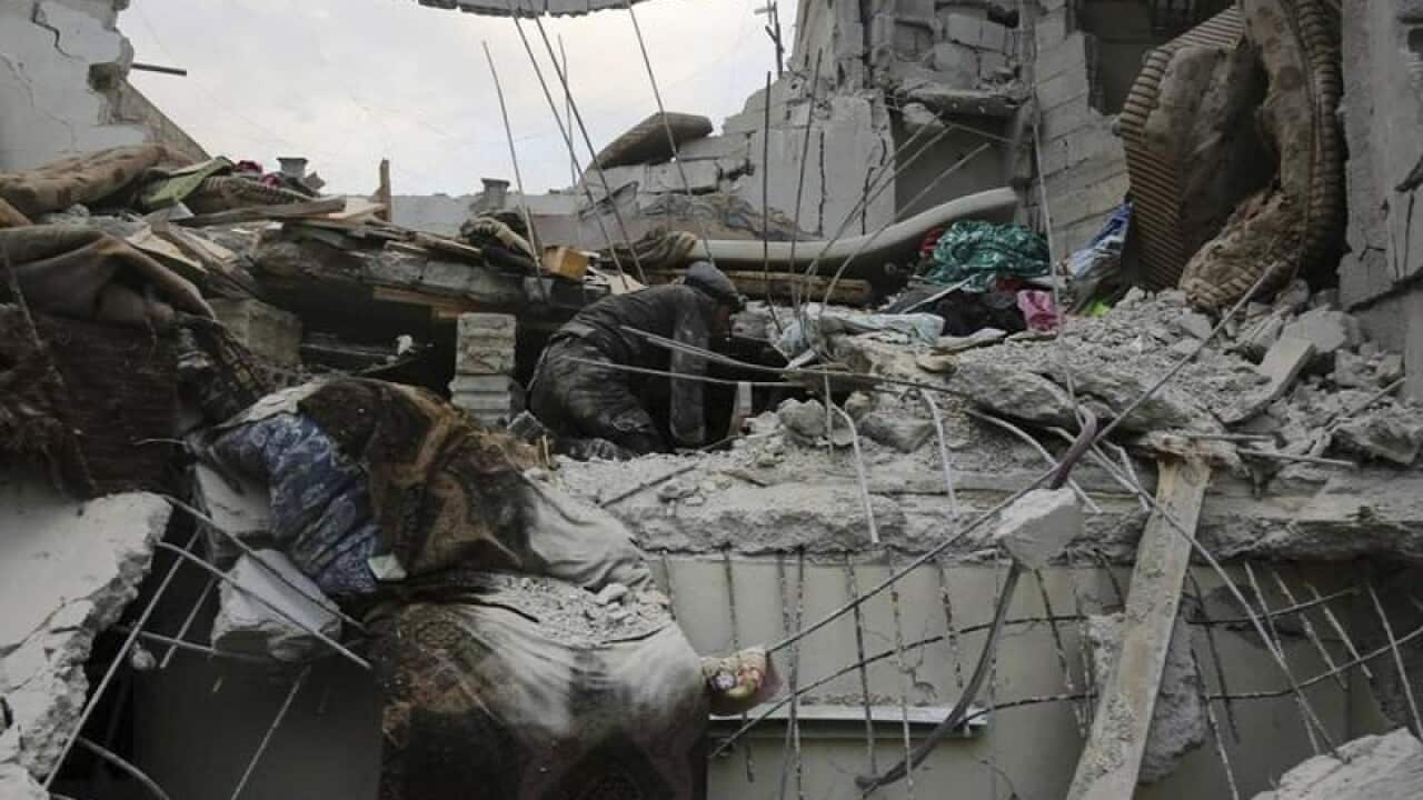 Members of the Syrian Civil Defense group search a destroyed house