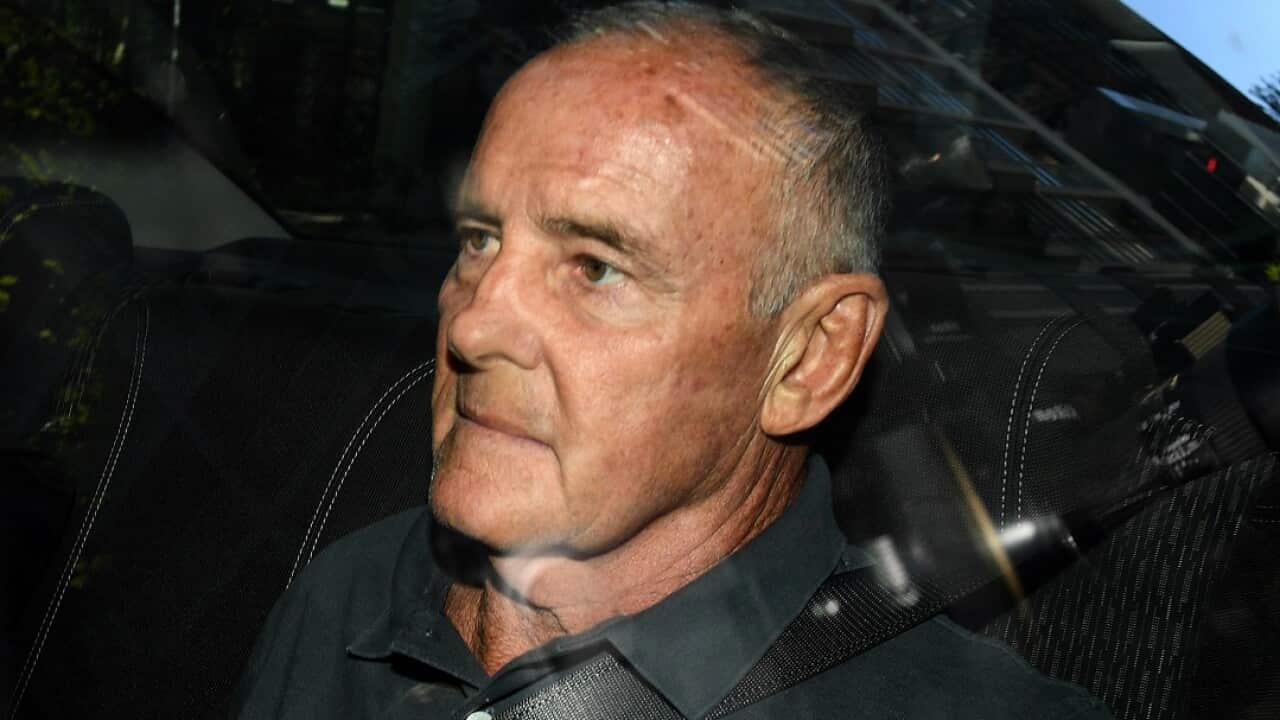 A man in a black shirt inside a car.