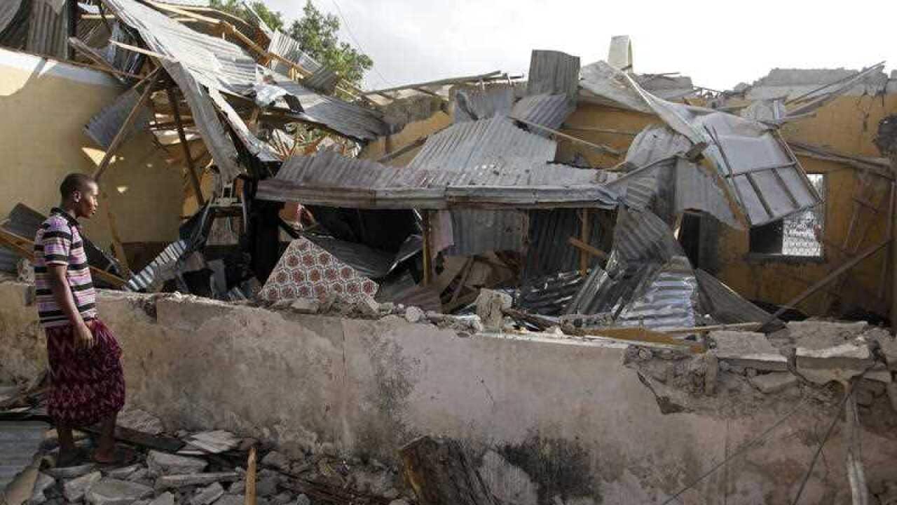 A Somali man look at his destroyed house, Saturday, Feb. 27, 2016 after a suicide car bomb on Friday night in Mogadishu, Somalia.