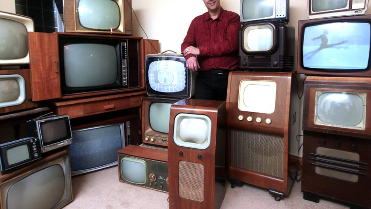 A collection of vintage black and white televisions.