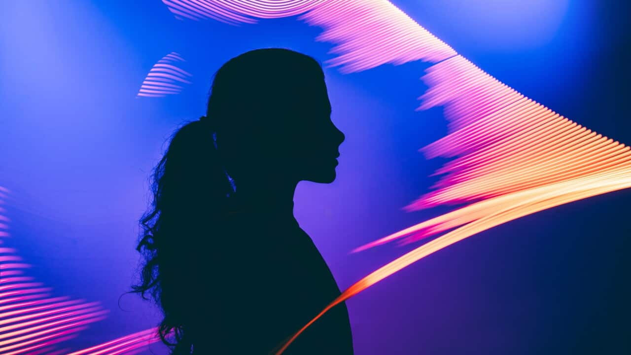 A metaphoric portrait of a human interacting with an AI, illuminated by the facial authentication glow to explore the virtual Universe