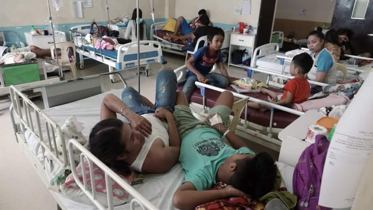 Patients suffering from dengue fever share beds at a government run hospital on the island of Samal, Zamboanga del Norte