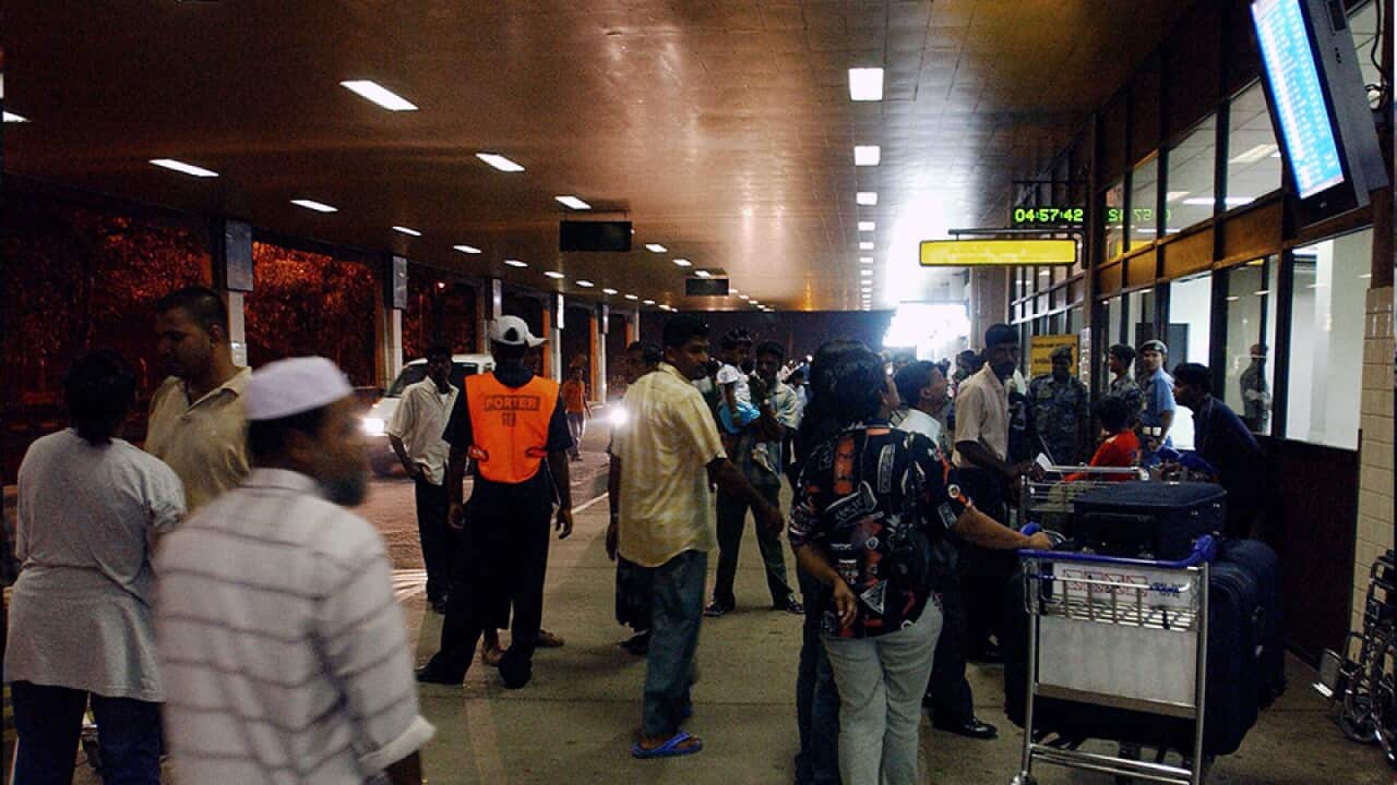 Passengers look at flight schedule outsi