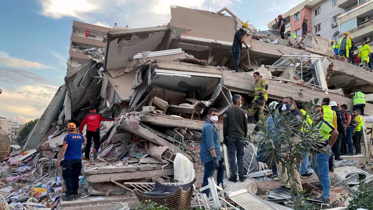 Rescue workers try to save people trapped in the debris of a collapsed building, in Izmir, Turkey, Friday, Oct. 30, 2020
