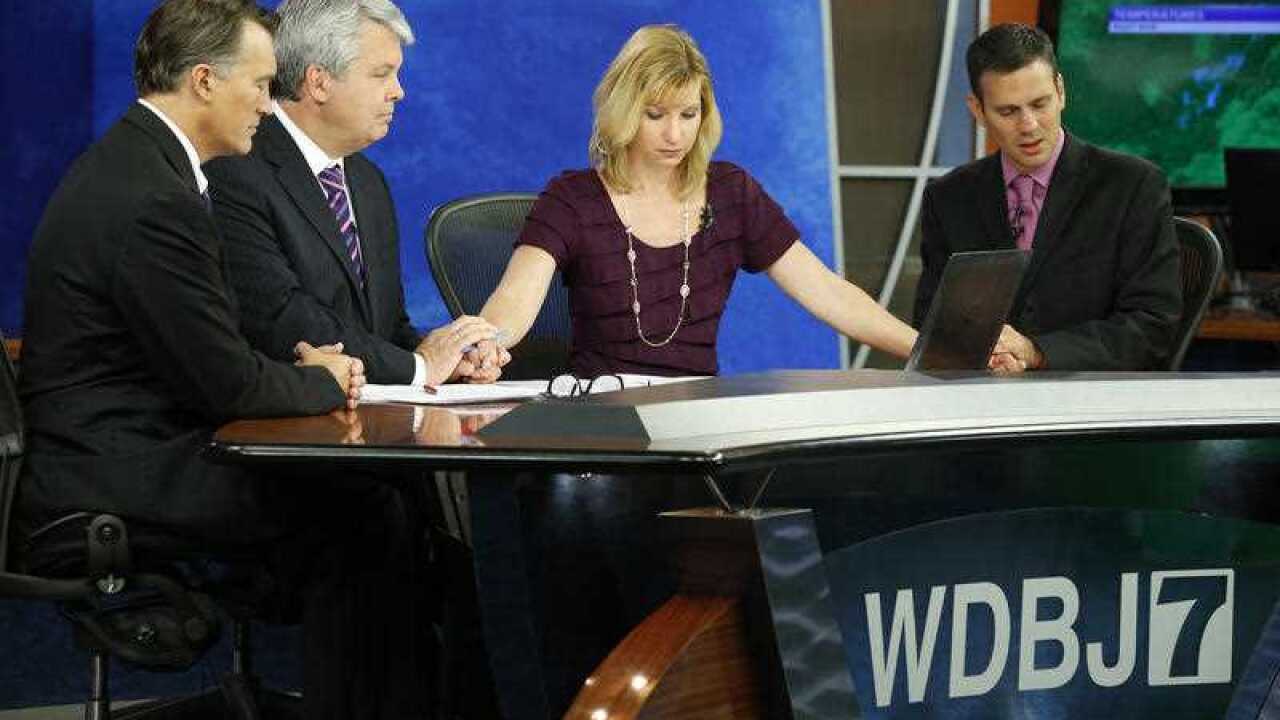 WDBJ-TV7 meteorologist Leo Hirsbrunner, right, wipes his eyes during the early morning newscast as anchors Kimberly McBroom and Steve Grant as they observe a moment of silence during the early morning newscast at the station (AP Photo/Steve Helber)