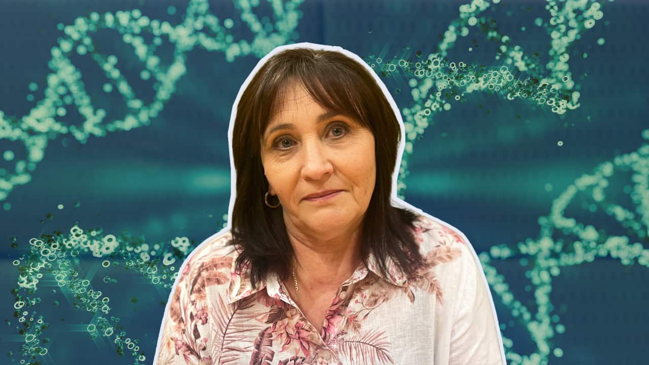 a middle-aged woman in a pink shirt with a background of blue DNA chains