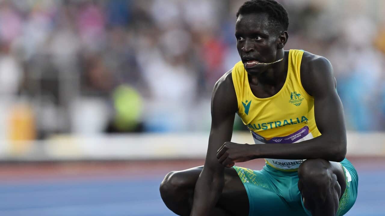 A man crouching down on a track.