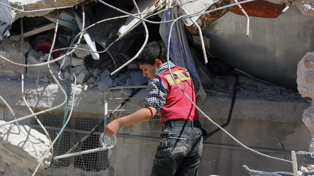 A Syrian boy inspecting the rubble of houses after airstrikes, Aleppo
