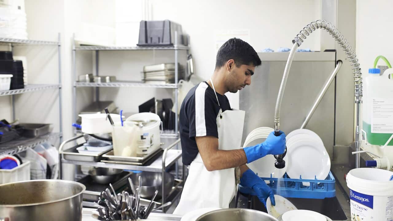 Man washing dishes in commercial kitchen