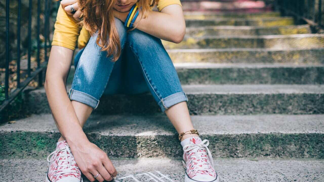 Unhappy girl writes help on the ground