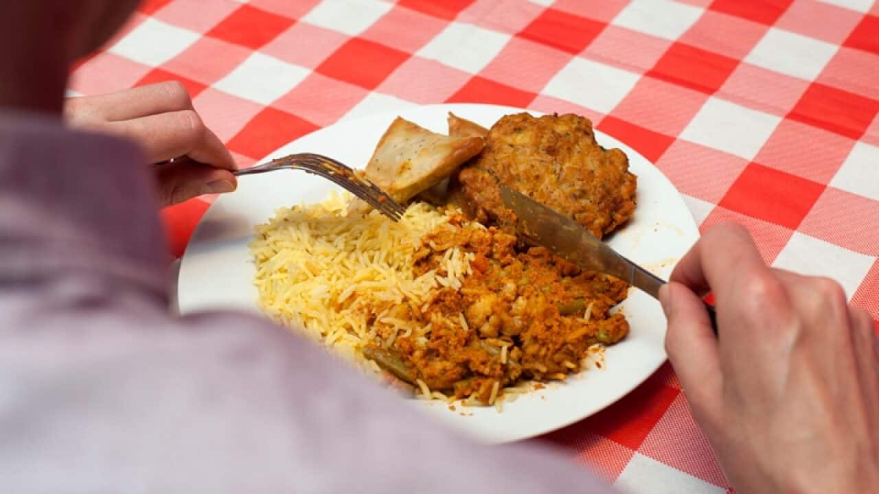A dish of vegetable tikka masala, rice, samosas and an onion bhaji