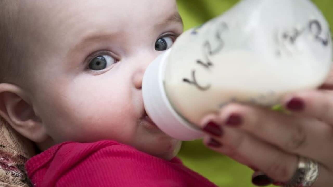 A baby feeding on a bottle.