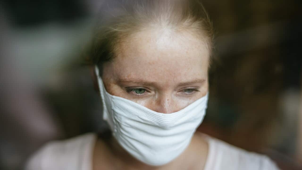 Long Covid - Woman with mask behind window