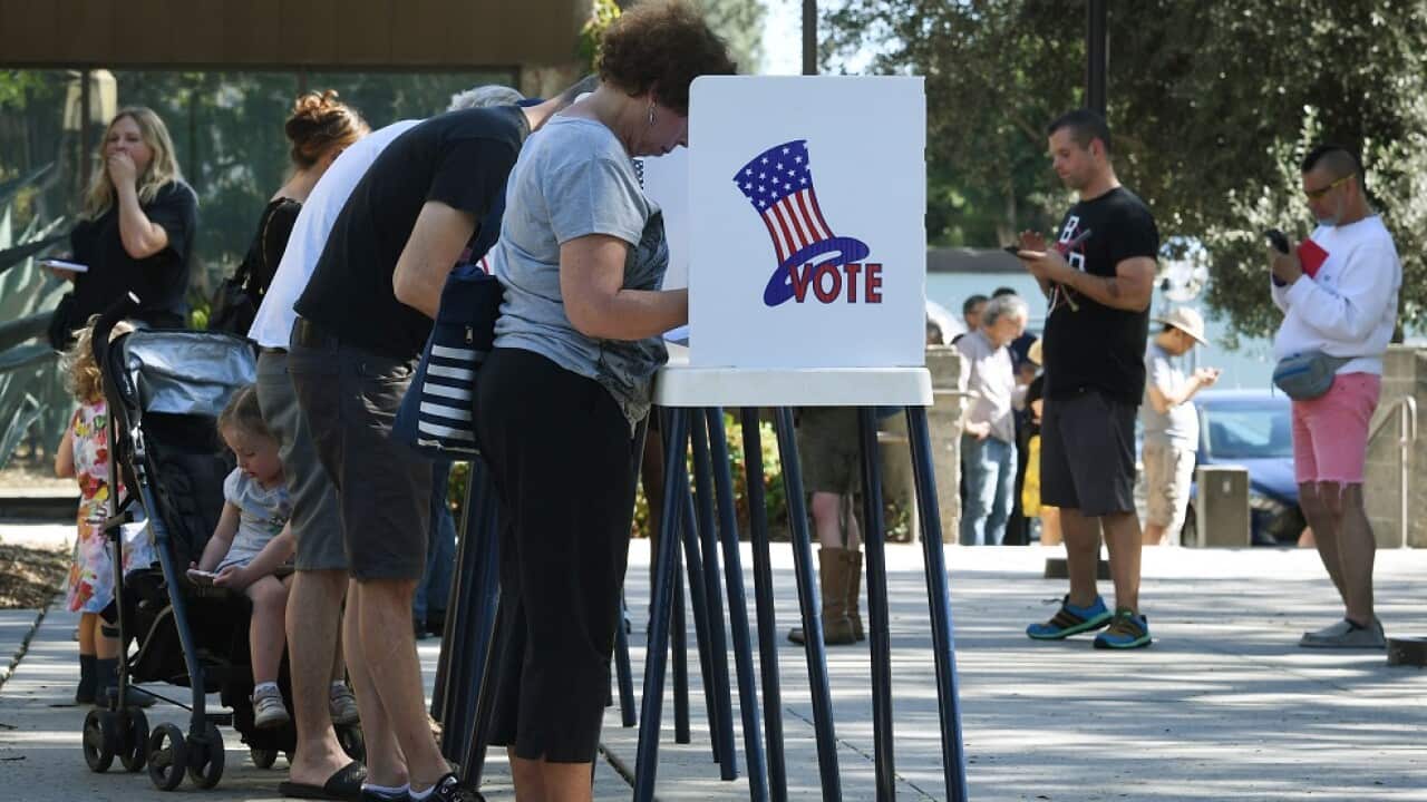 People vote at outdoor booths during early voting for the midterm elections in Pasadena, California.