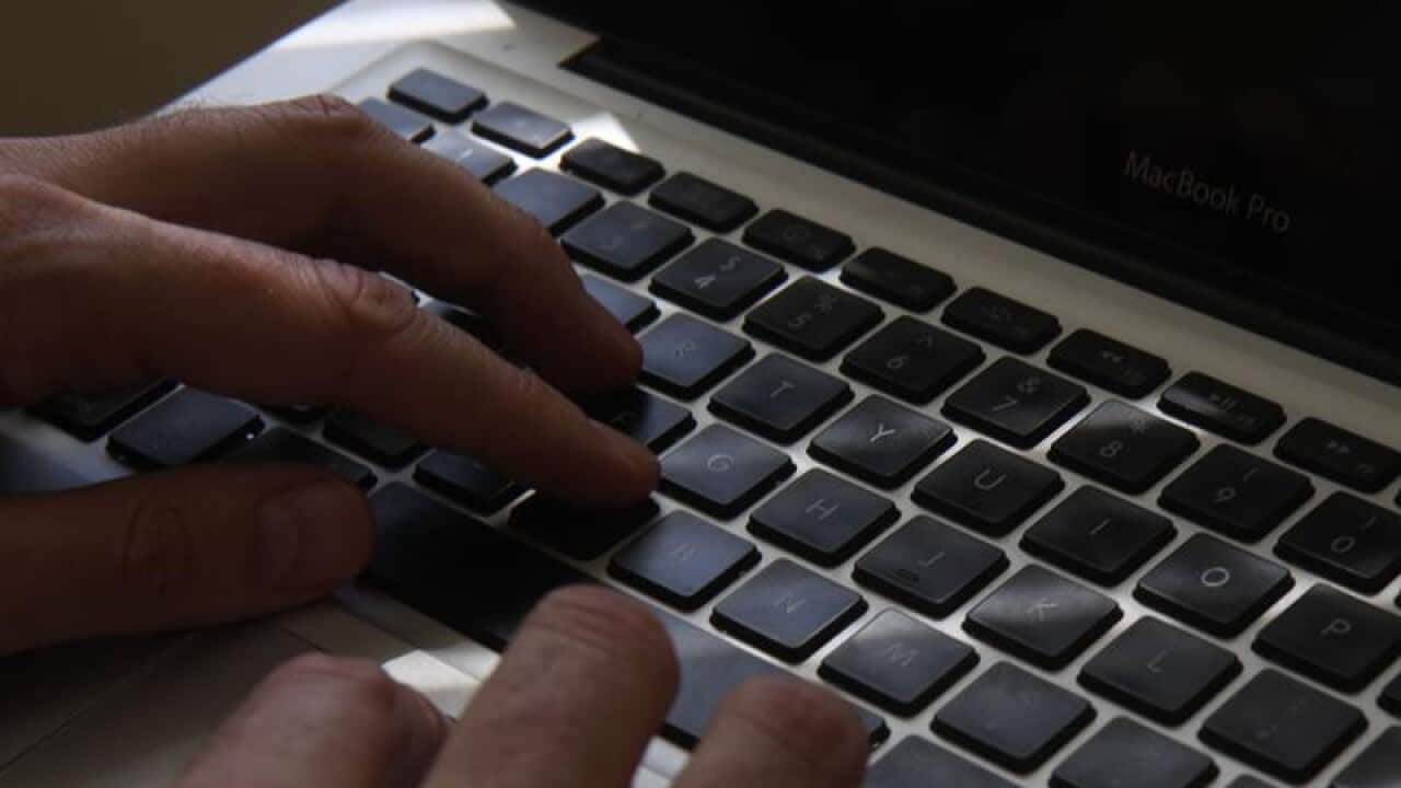 Fingers typing on a laptop