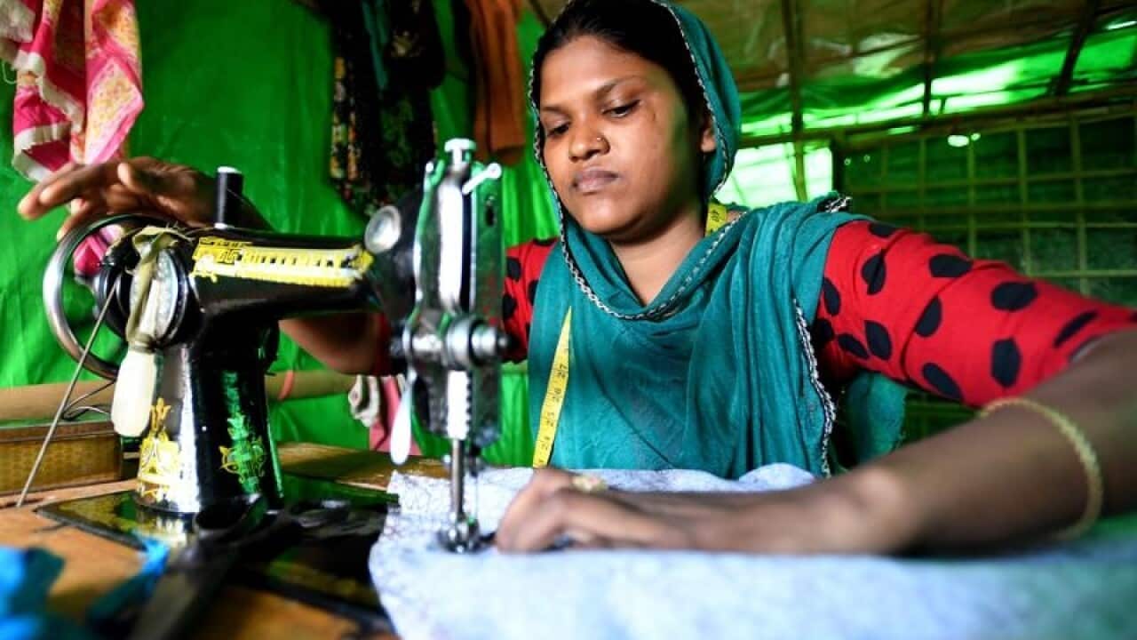 Sabura, a Rohingya refugee, sits at her sewing machine at a camp.