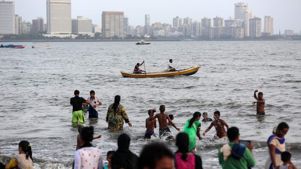 People refresh themselves from the heat on a hot afternoon, off the coast of Arabian sea in Mumbai, India.