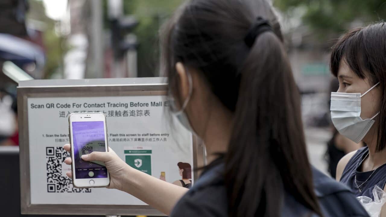 Visitors scan a QR code, used for contact tracing,