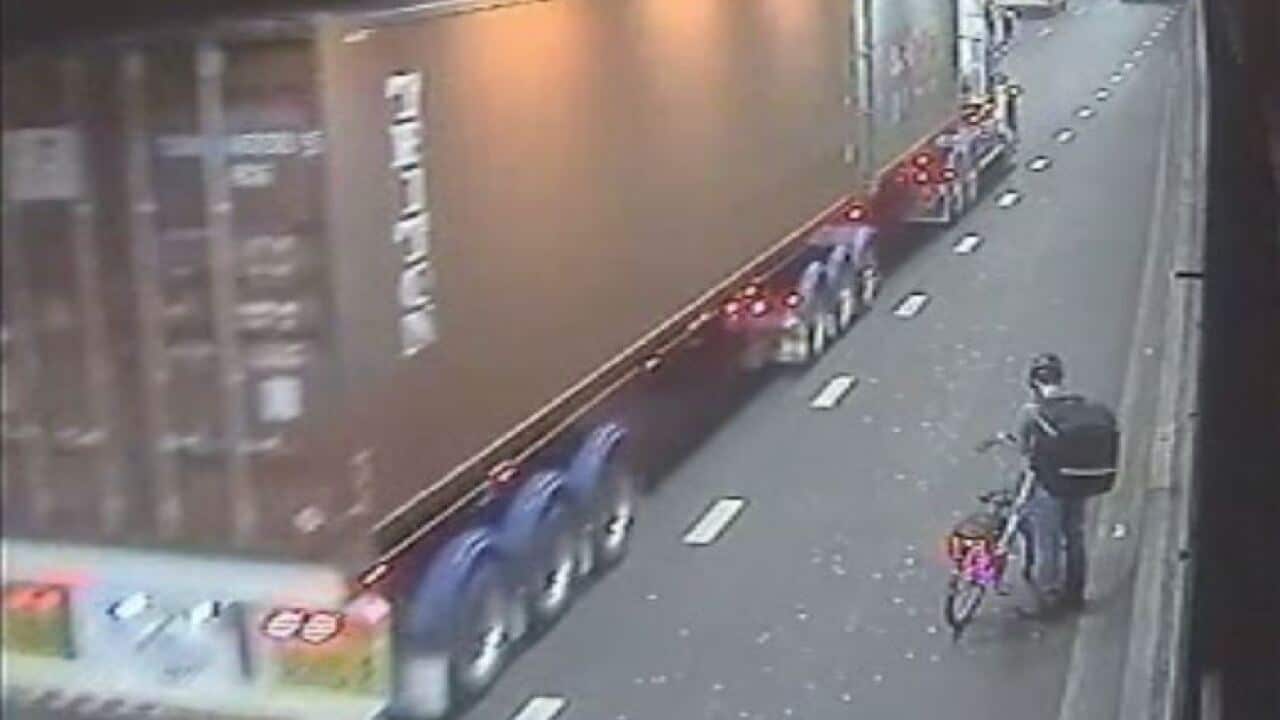 A food delivery cyclist is seen on CCTV in Sydney’s Eastern Distributor tunnel as a truck passes.
