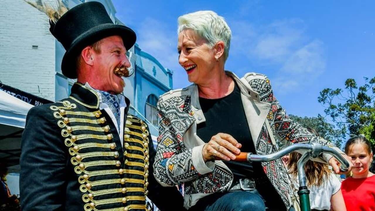 Kerryn Phelps is seen on a penny-farthing bicycle while campaigning.