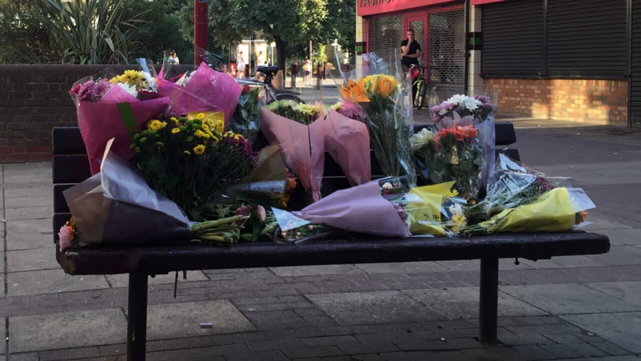 Flowers are placed near the scene of an attack on a Polish man