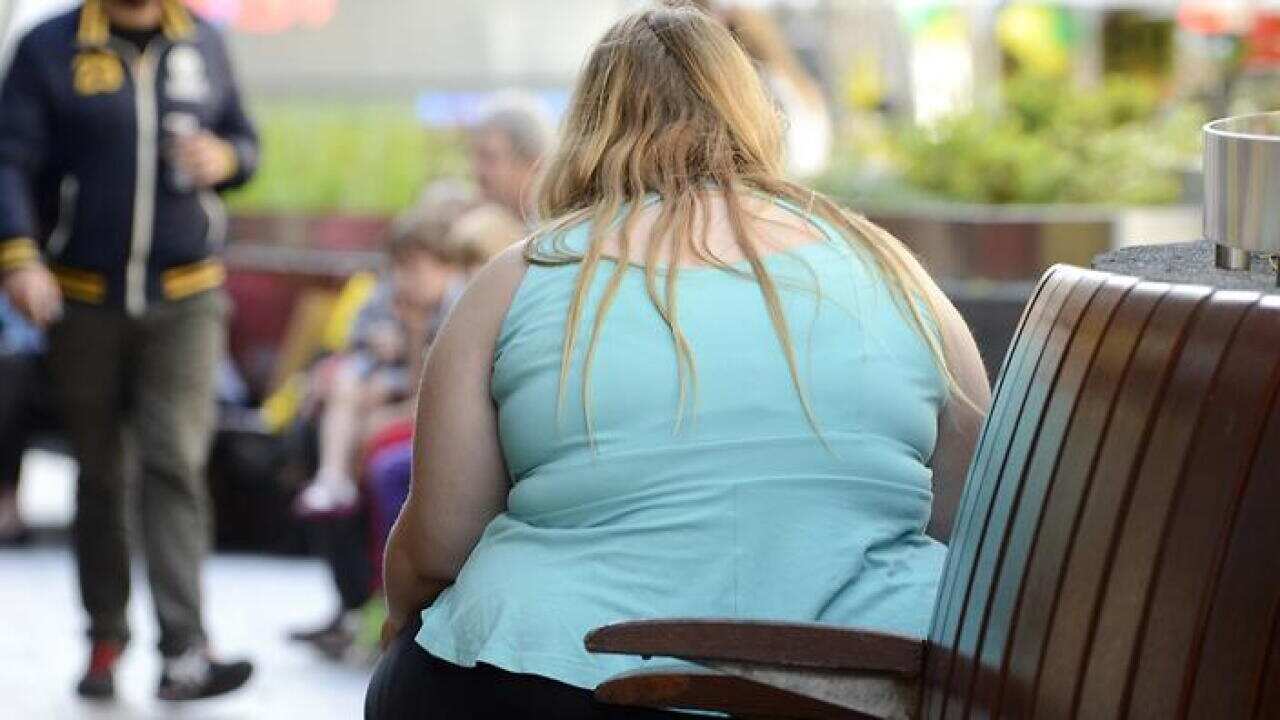 An obese woman sits on a street bench in Brisbane, Tuesday, July 2, 2013. (AAP Image/Dan Peled) NO ARCHIVING