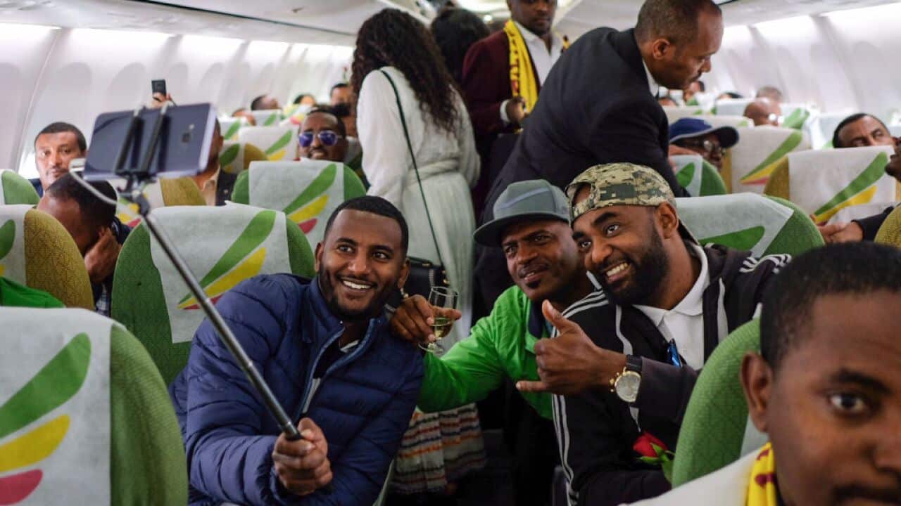 Passengers pose for a selfie picture inside an Ethiopian Airlines flight who departed from the Bole International Airport in Addis Ababa, Ethiopia, to Eritrea's capital Asmara on July 18, 2018.