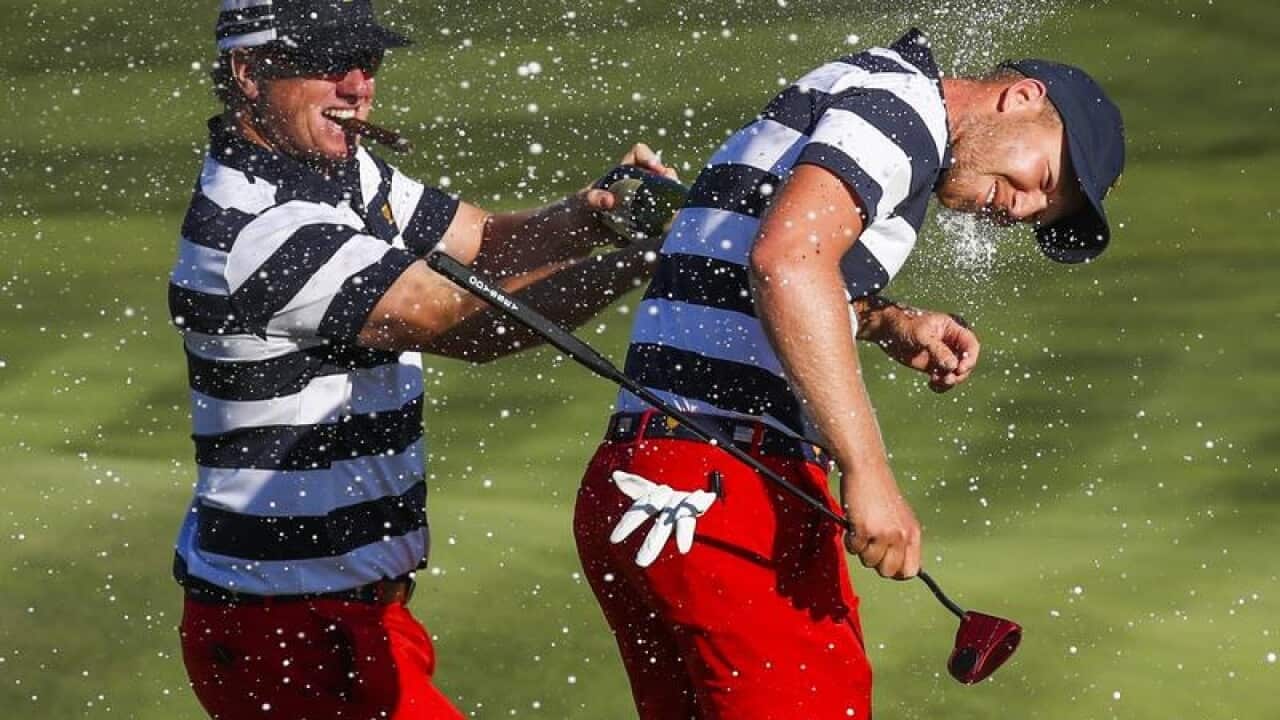 US team member Charley Hoffman (L) sprays down Daniel Berger (R)