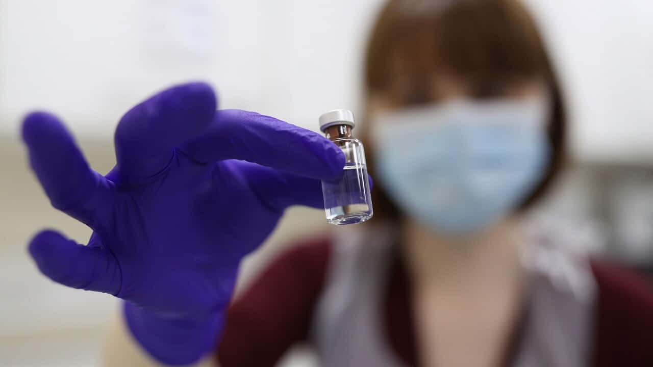A lab technician in London simulates preparation of the Pfizer vaccine