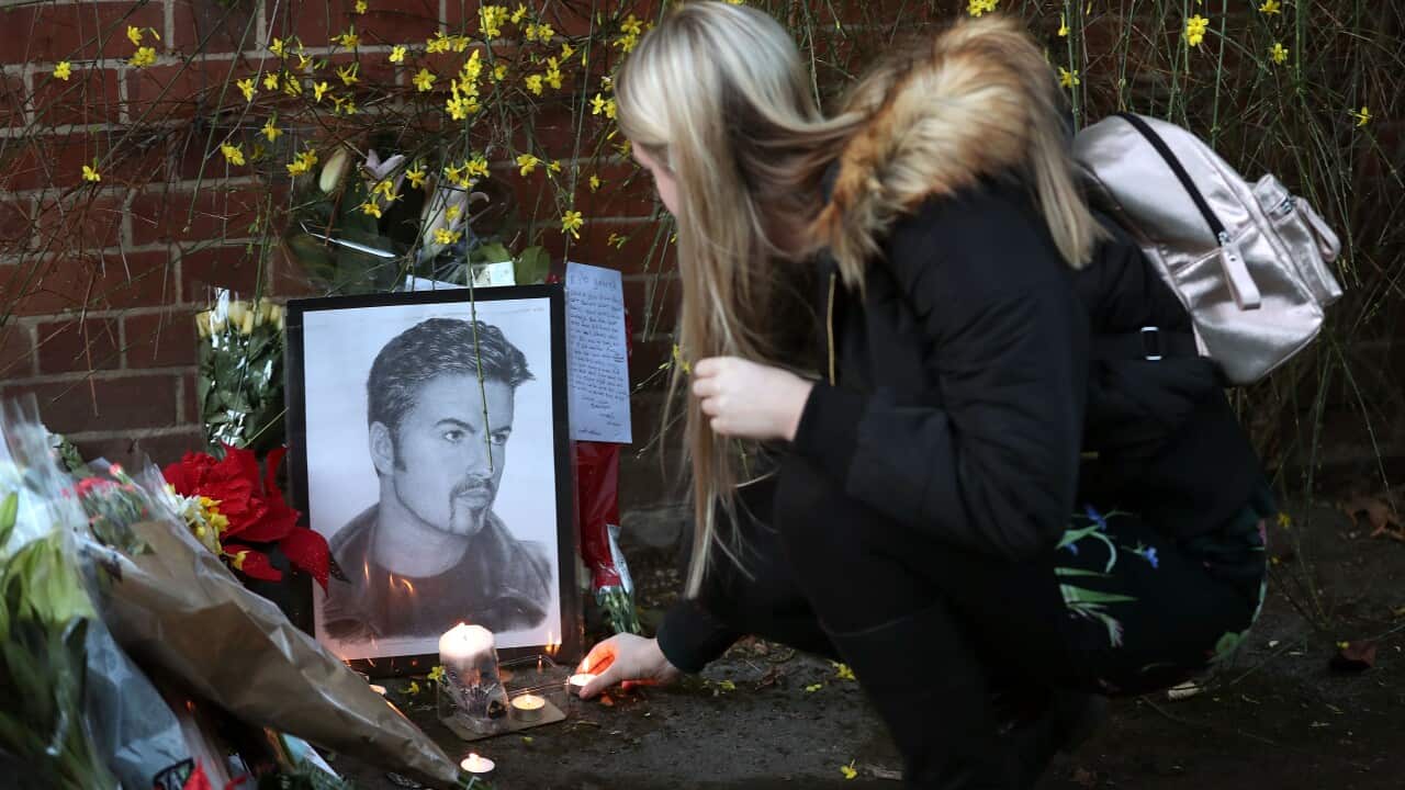A woman lays a candle outside the Goring house of George Michael in Oxfordshire as the pop superstar has died at the age of 53 from suspected heart failure.