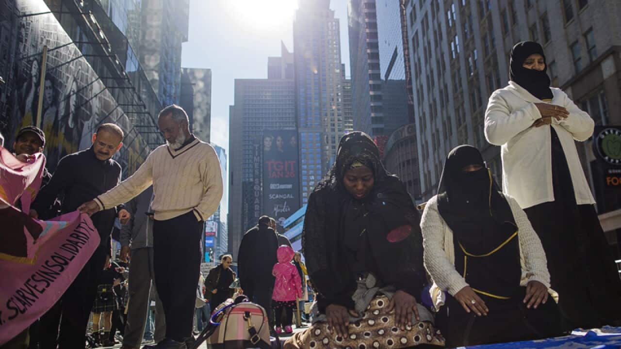 Women pray during a rally in Times Square