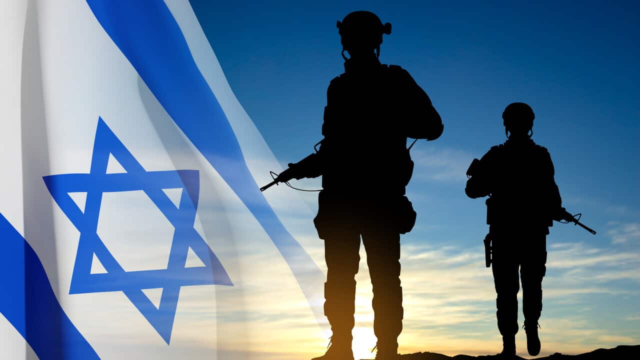 Silhouette of soldiers with the Israeli flag against the sunrise