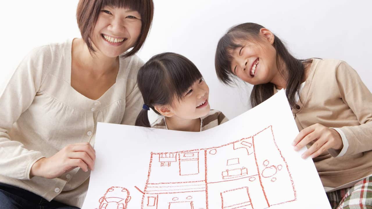 Mother and children holding a pictuere of room layout