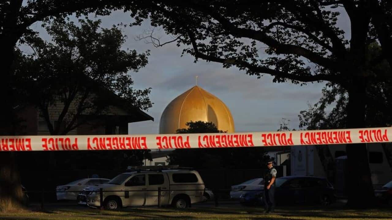 A police officer stands guard in front of the Masjid Al Noor mosque