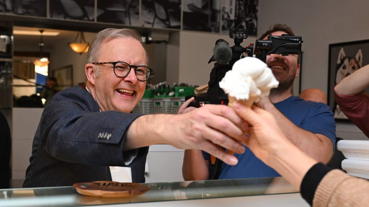 A man hands out an ice cream cone.