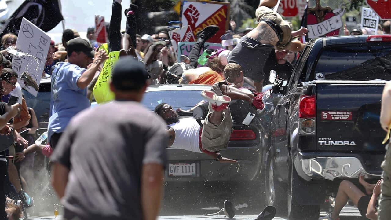 In this Aug. 12, 2017, file photo, people fly into the air as a vehicle is driven into a group of protesters demonstrating against a white nationalist rally in Charlottesville, Va.