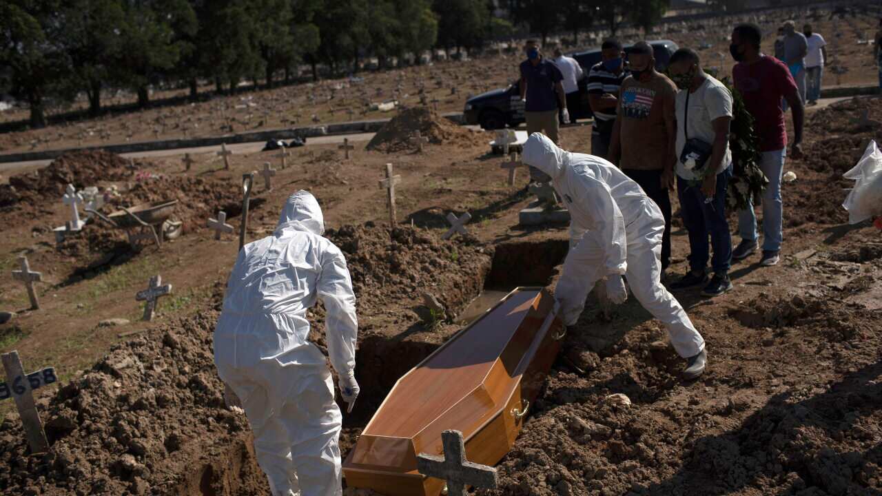 Cemetery workers in protective gear bury Amanda da Silva, 22, who died of COVID-19 at the Caju cemetery, in Rio de Janeiro, Brazil.
