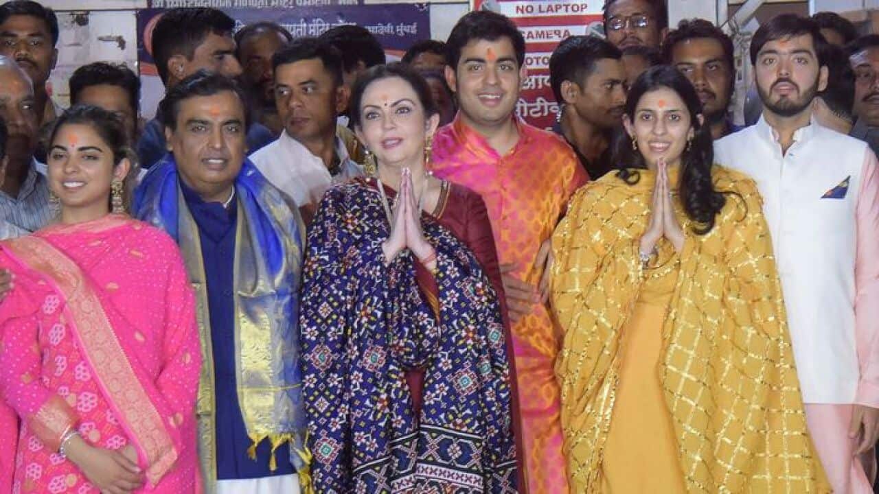 Indian business Mukesh Ambani (2L) and his wife Nita (C) along with their children Isha (L),Akash (3R), Anant (R) at the Siddhivinayak temple in Mumbai.
