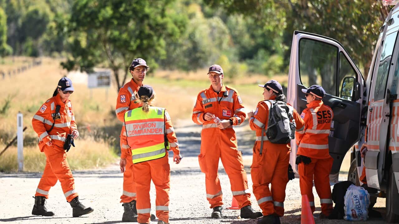 State Emergency Service workers speaking while standing next to a van.